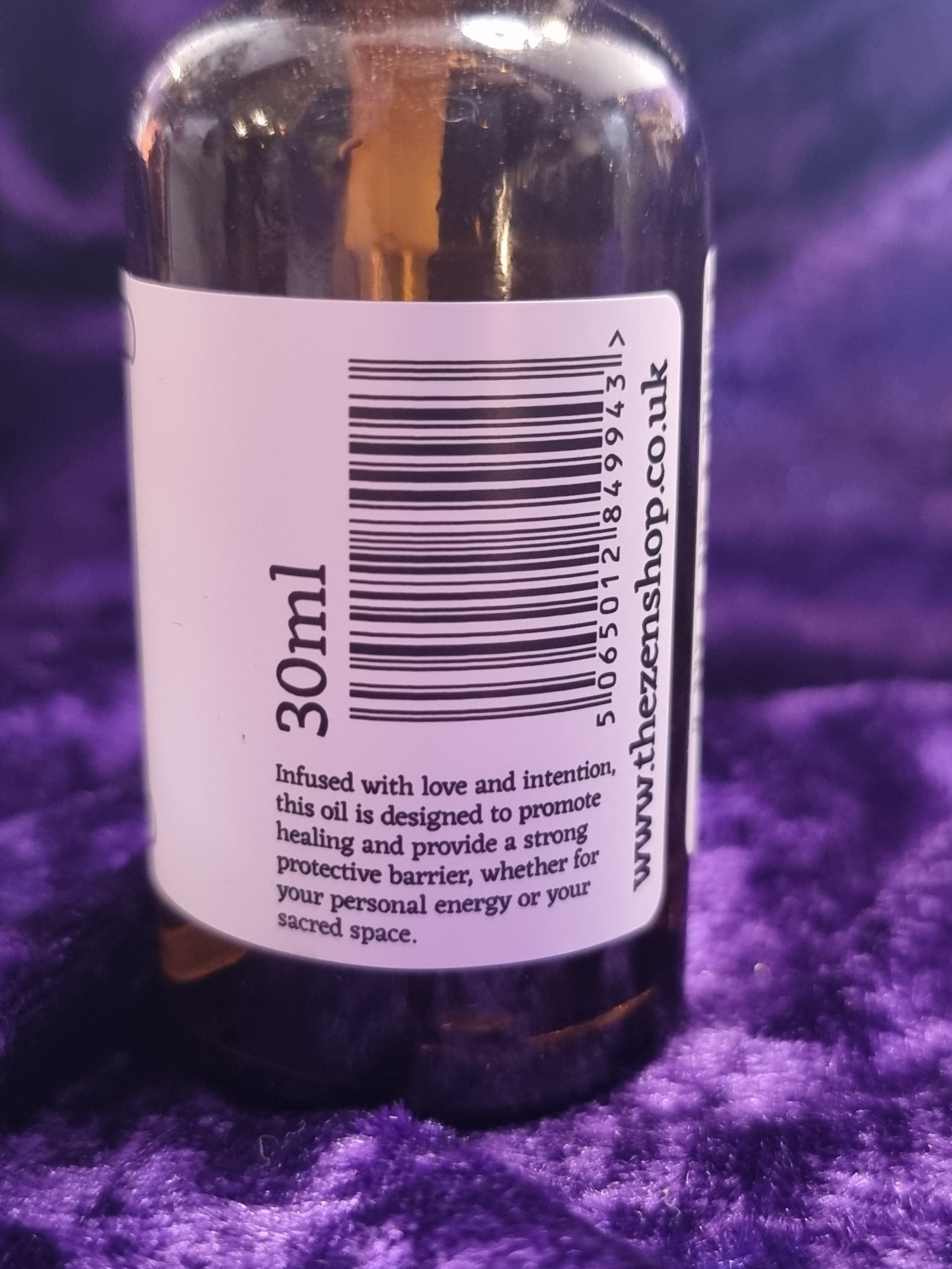Bottle label with '30ml' and a barcode on a purple fabric background