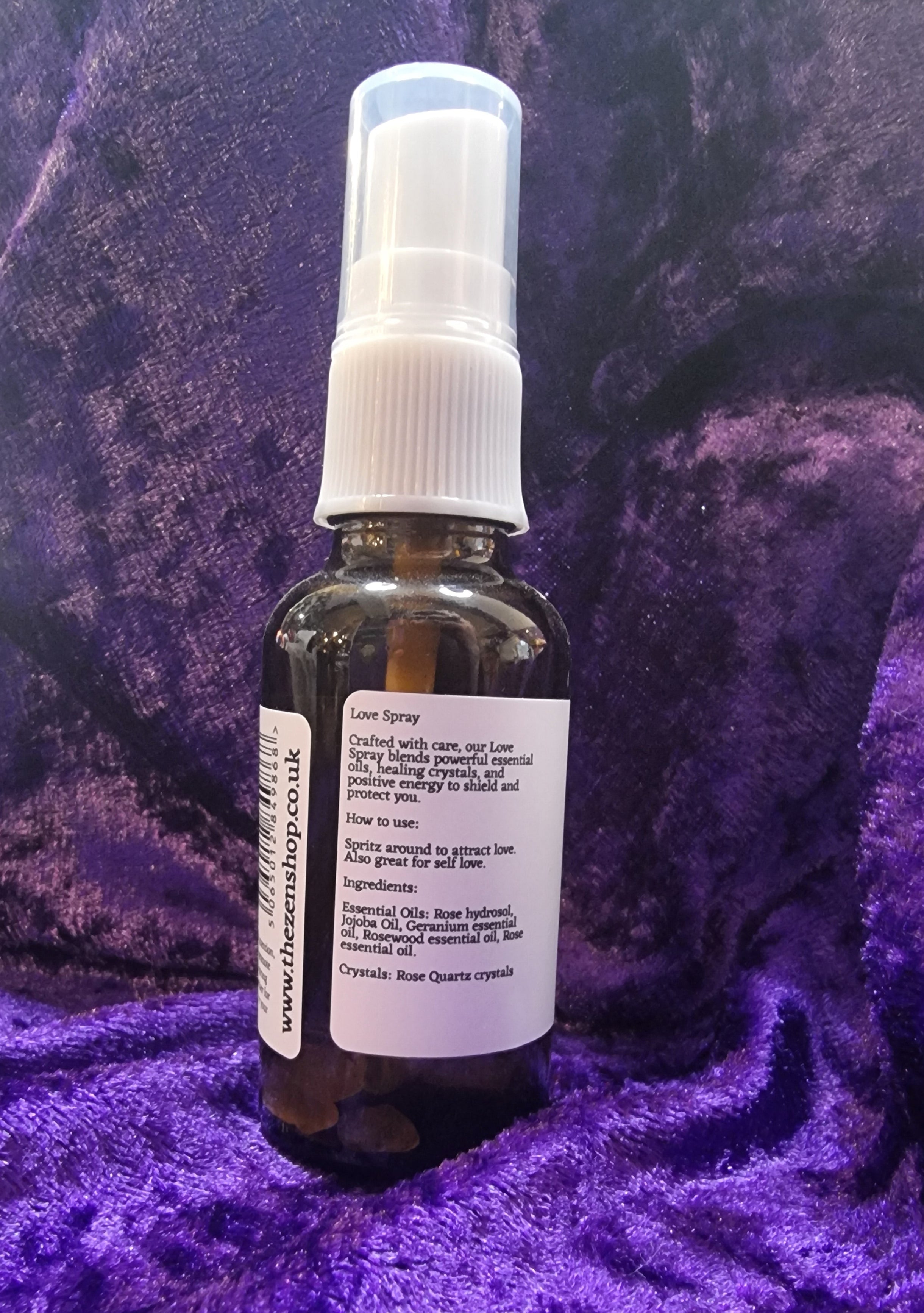 Small spray bottle with a label on a purple textured surface