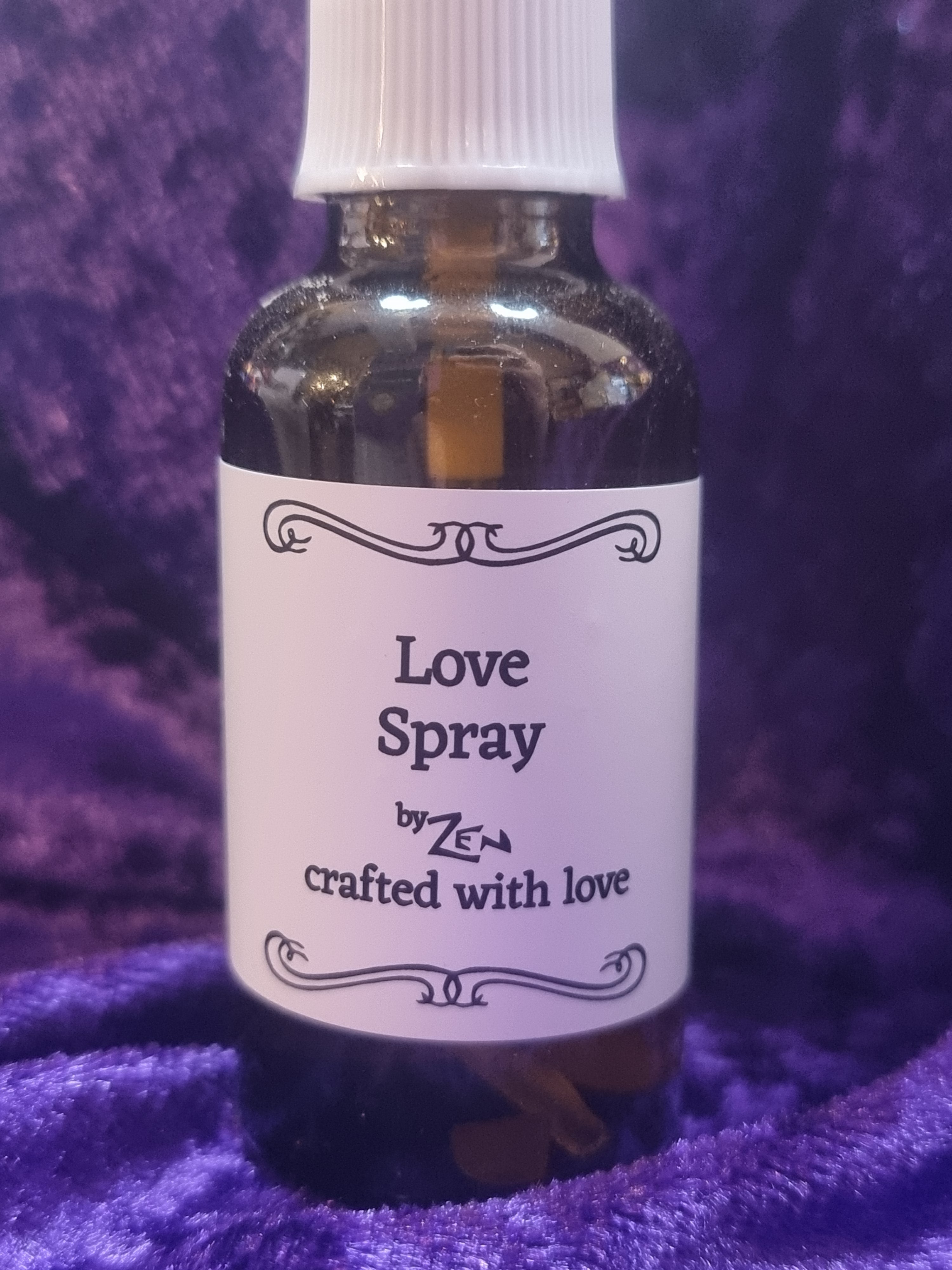 Love spray bottle with a purple label on a purple textured background
