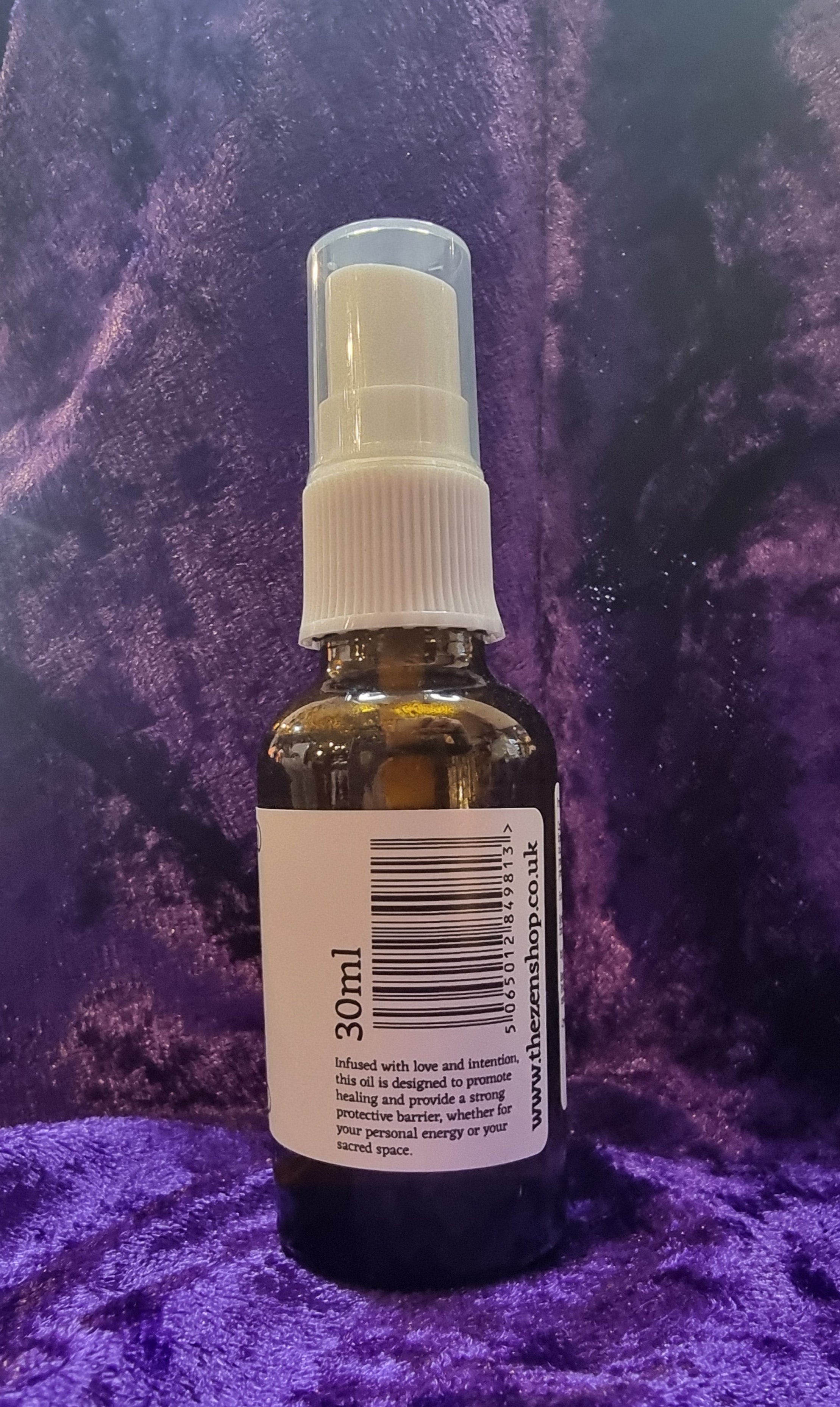 Small bottle with a spray nozzle on a purple textured surface