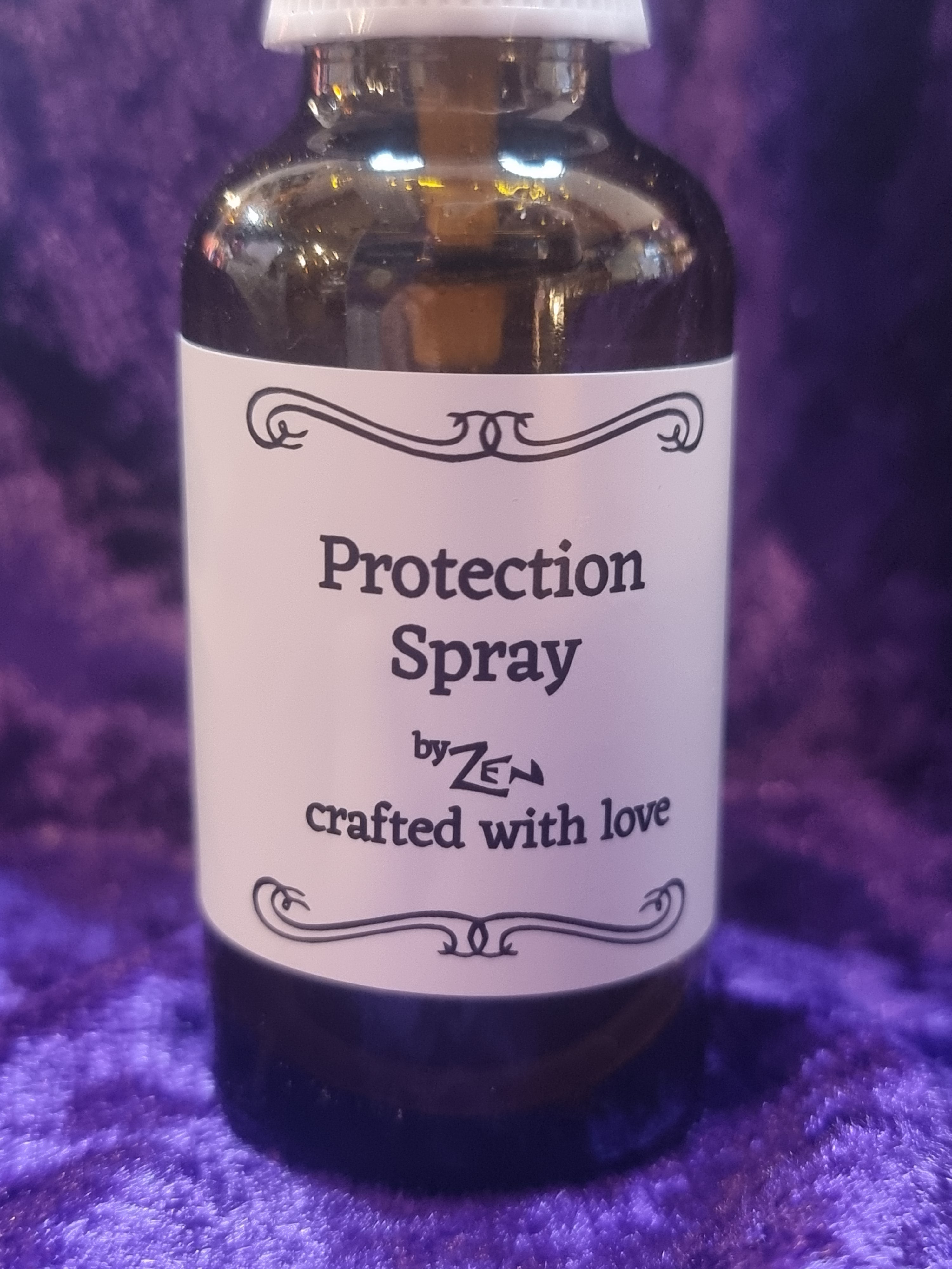 Bottle of 'Protection Spray' with a label on a purple textured background
