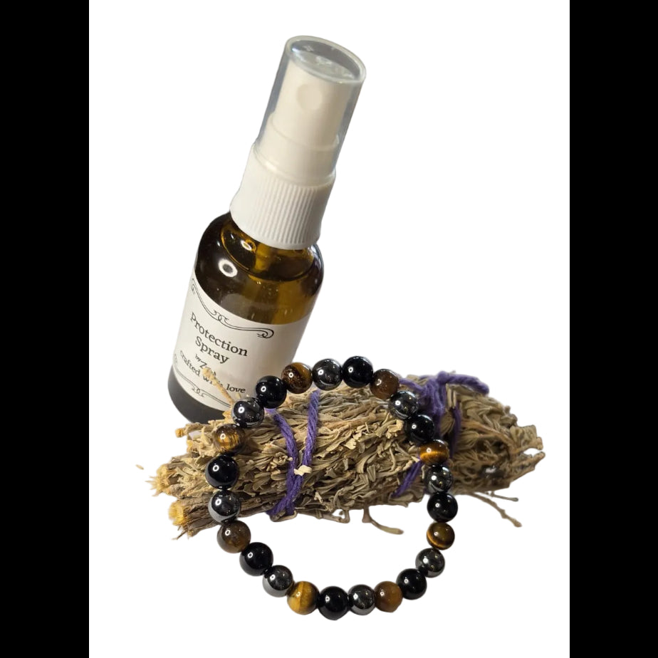 Bottle of essential oil with a spray nozzle on a piece of paper, next to a bracelet.