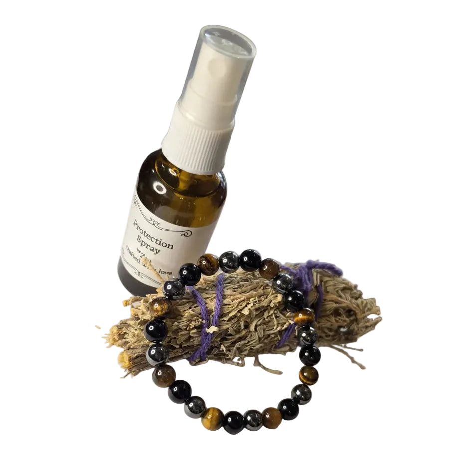 Bottle of essential oil with a spray nozzle on a piece of paper, next to a bracelet.