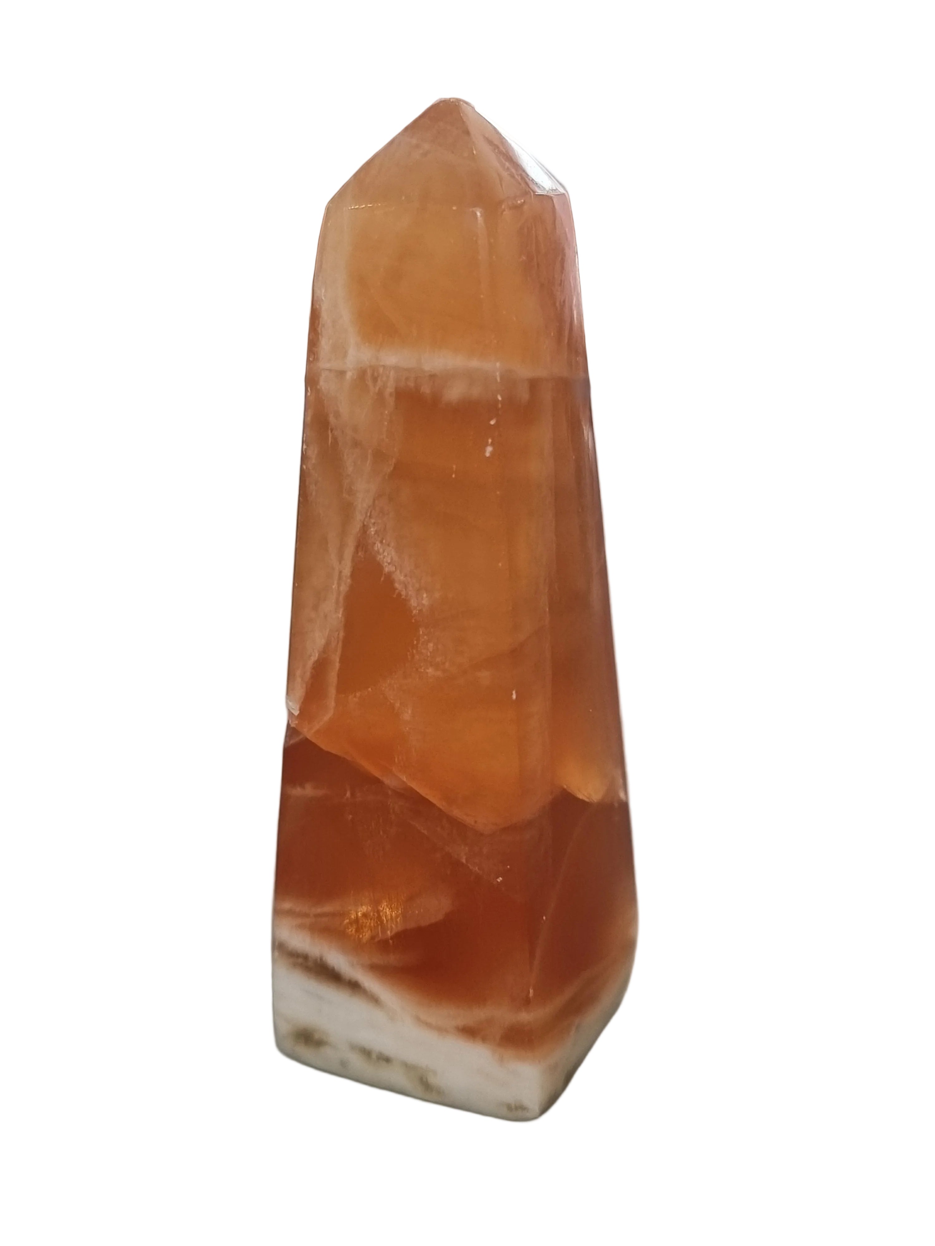 Polished orange crystal on a gray surface