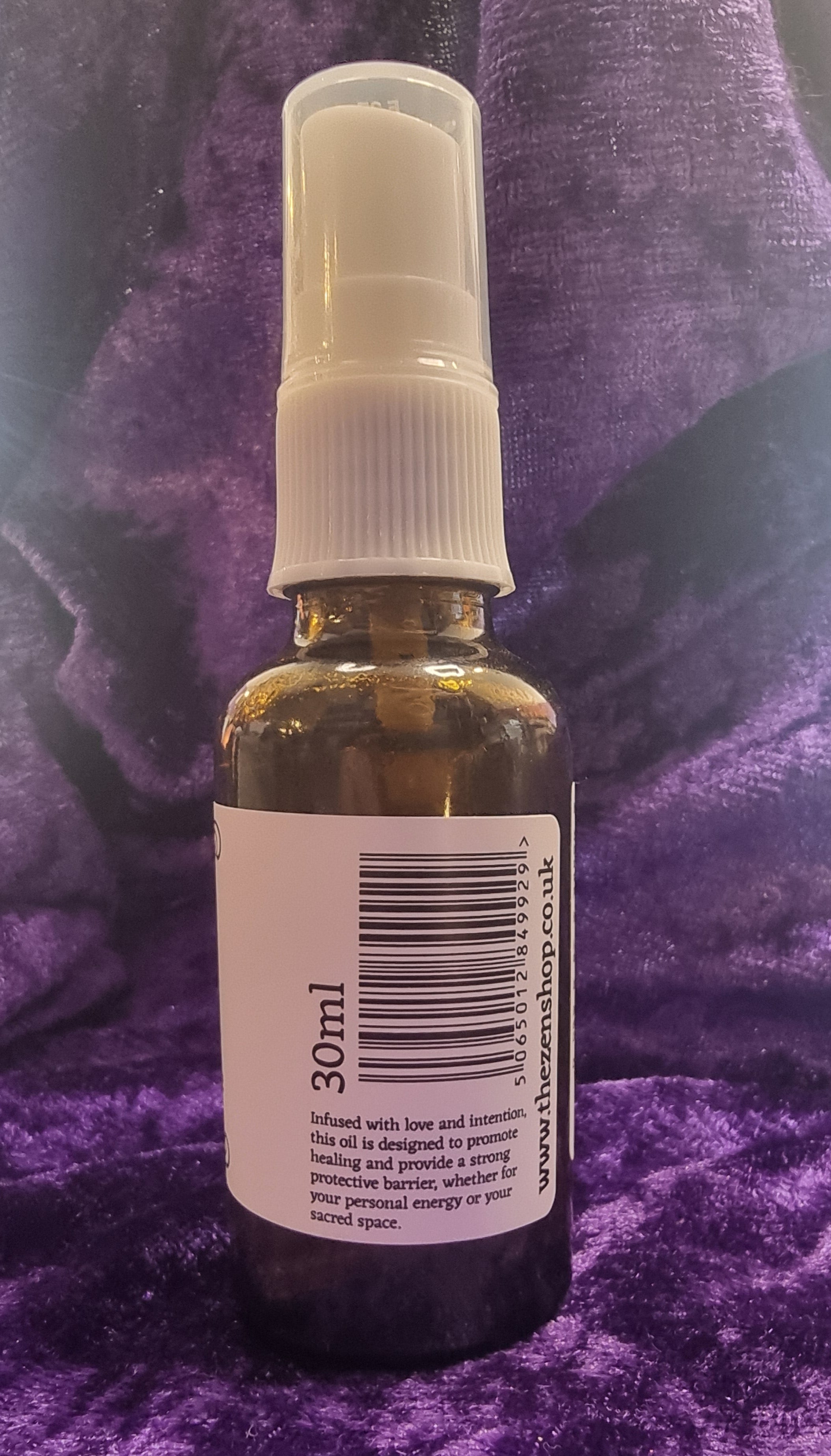 Small spray bottle with a label on a purple textured surface