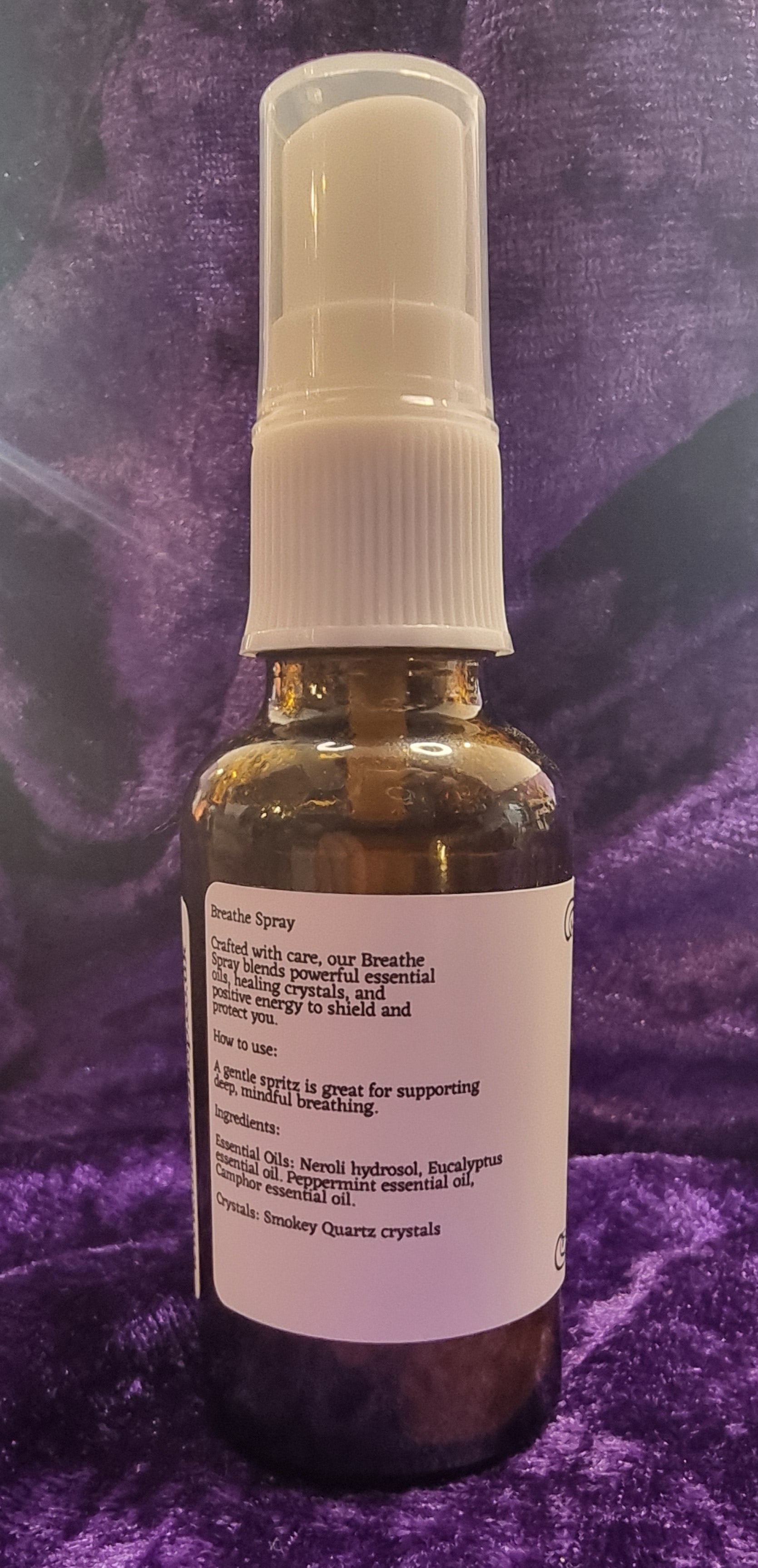 Small spray bottle with a label on a purple textured surface
