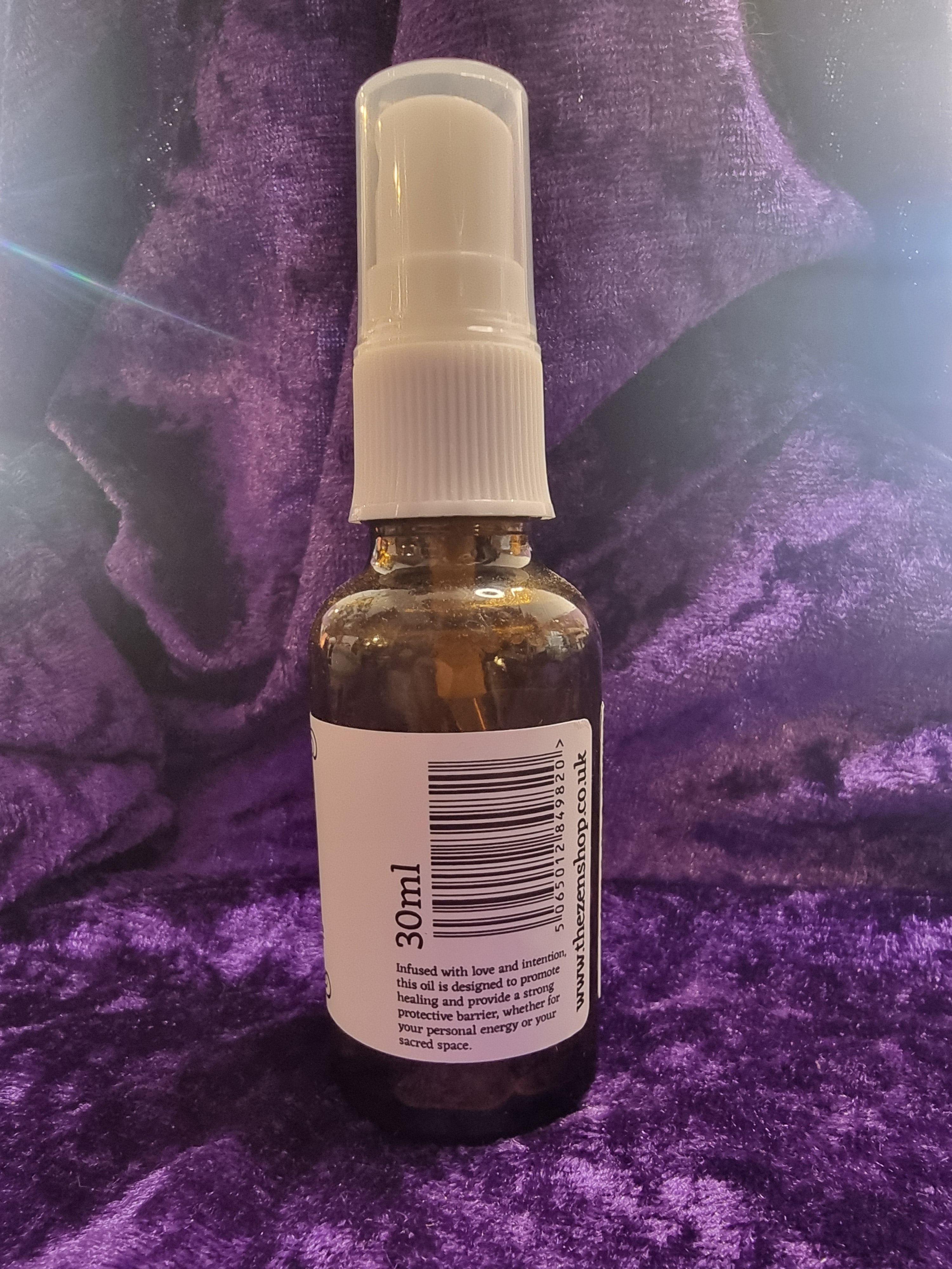 Small bottle with a spray nozzle on a purple textured surface