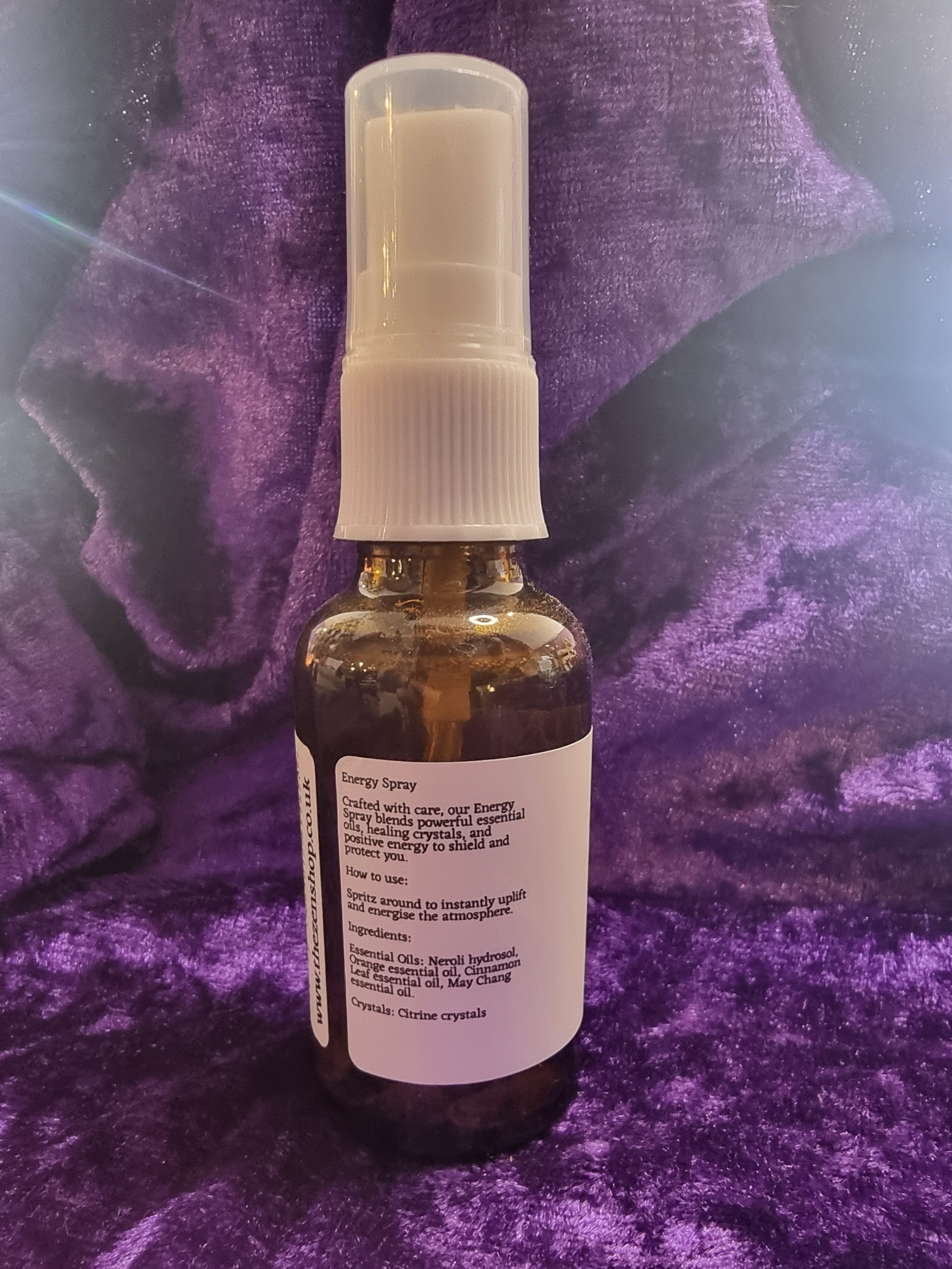 Bottle with a white label and spray nozzle on a purple textured surface