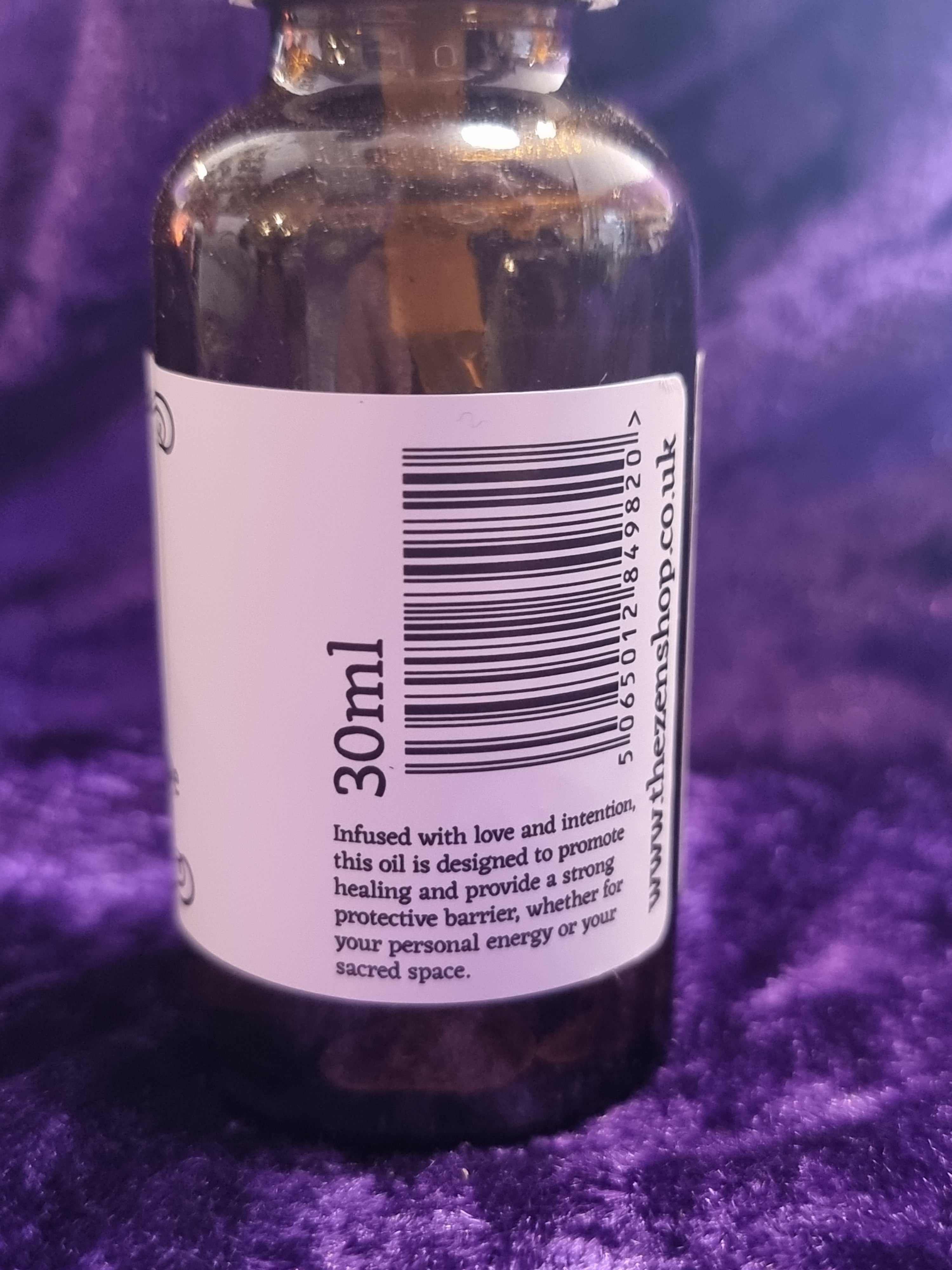 Bottle with a label showing '30ml' and a barcode on a purple textured background