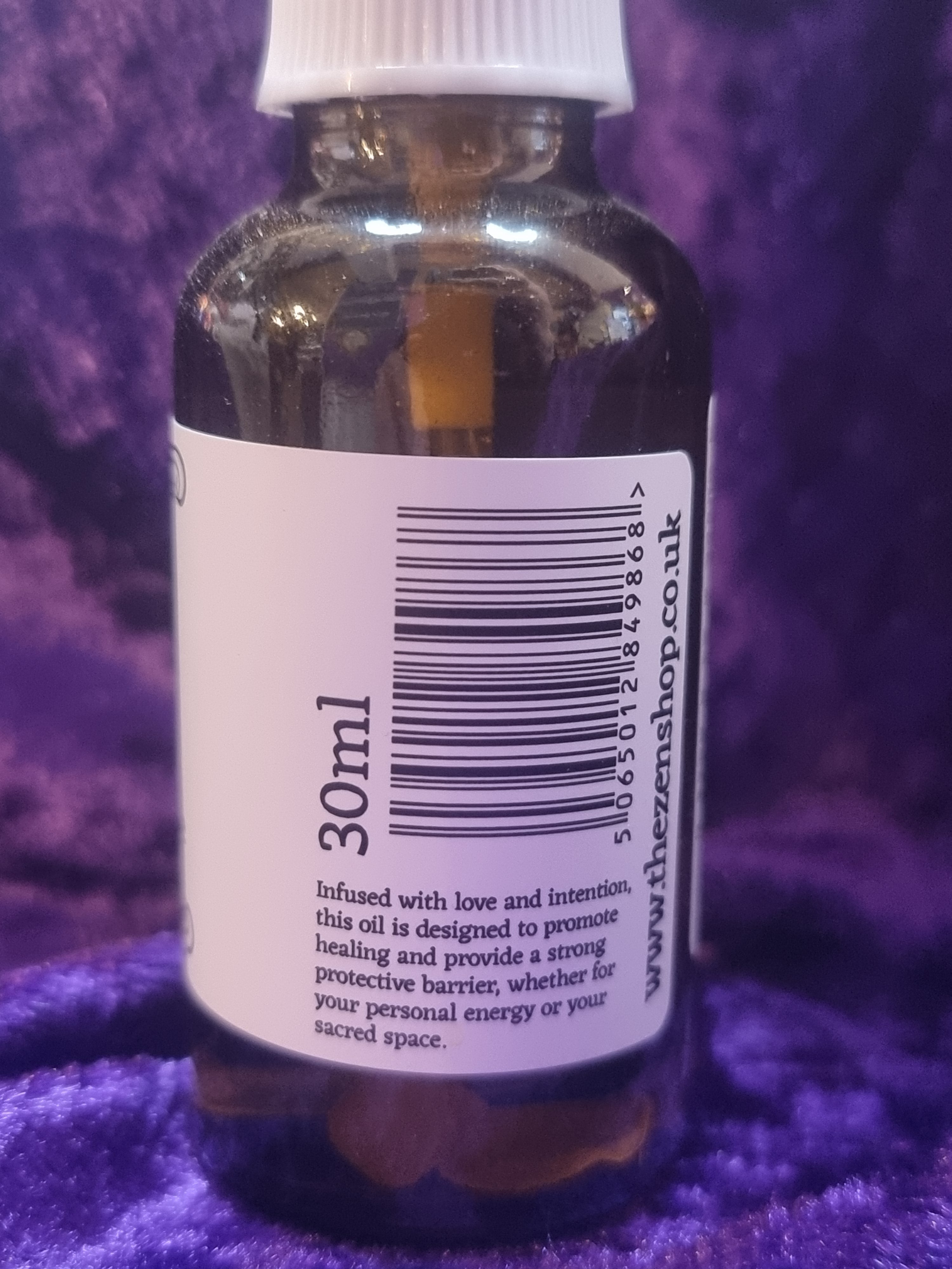 Bottle with a label showing '30ml' and a website URL on a purple textured background