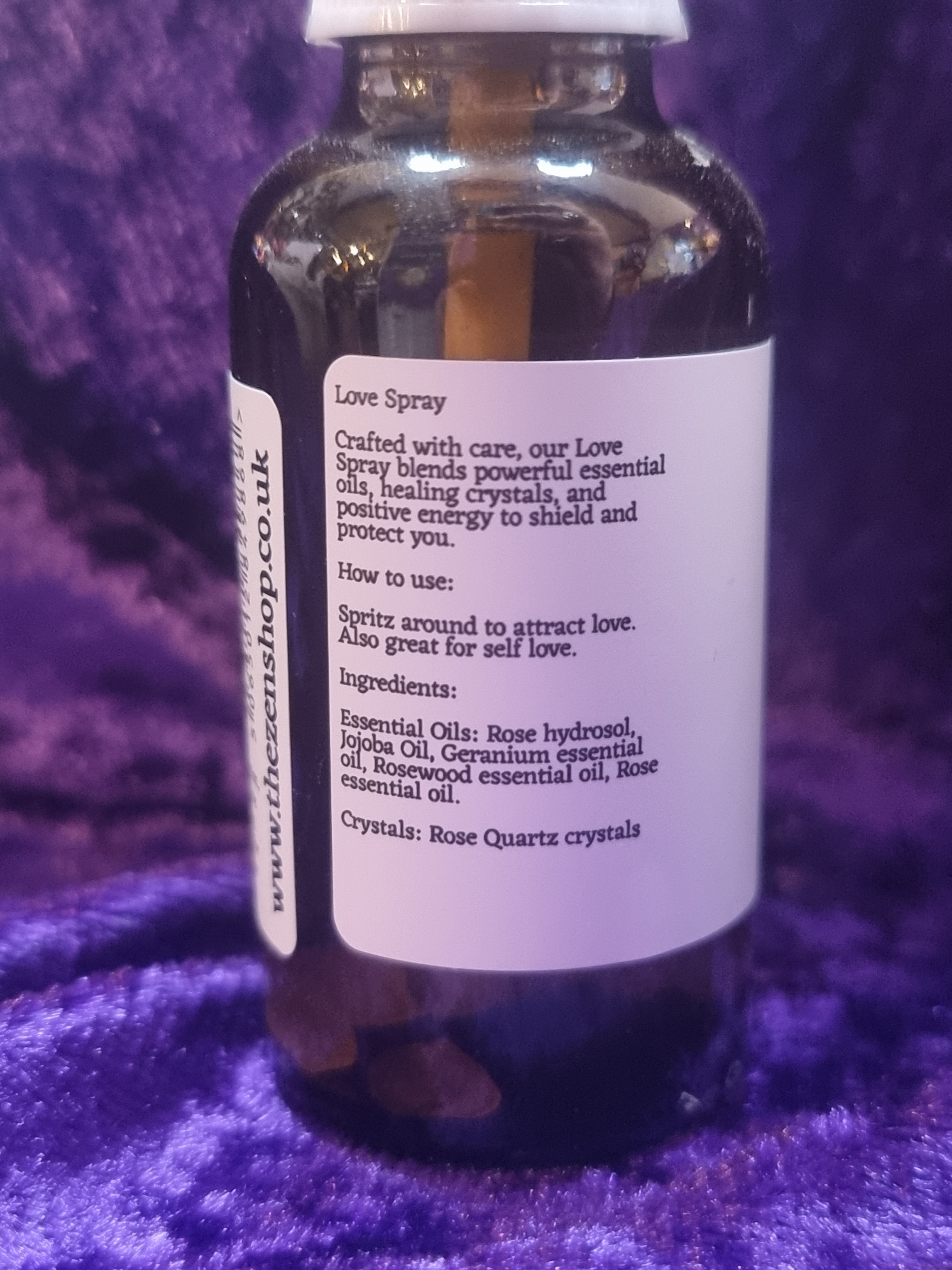 Bottle of love spray with label on a purple fabric background