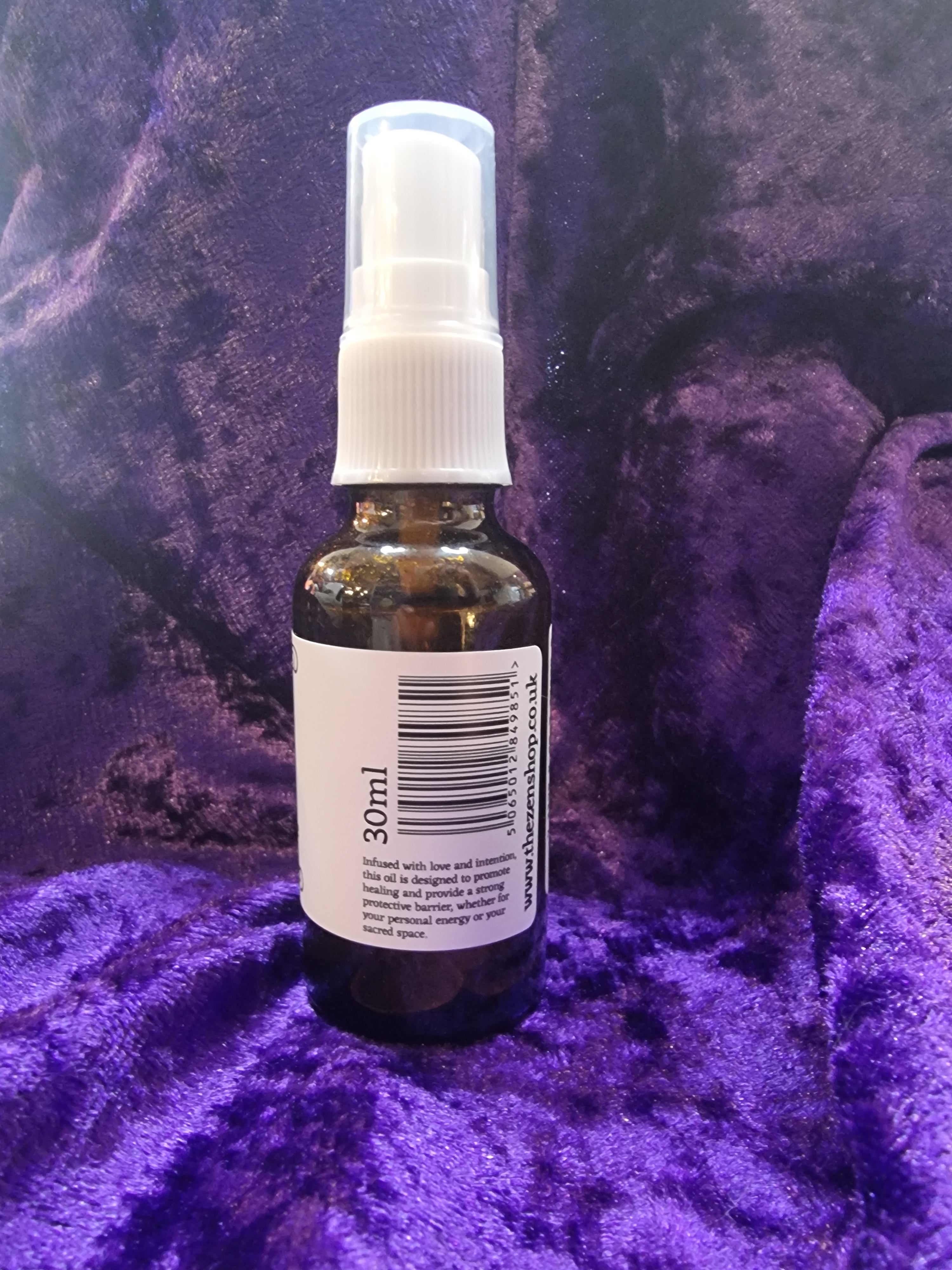 Small spray bottle with a label on a purple textured surface