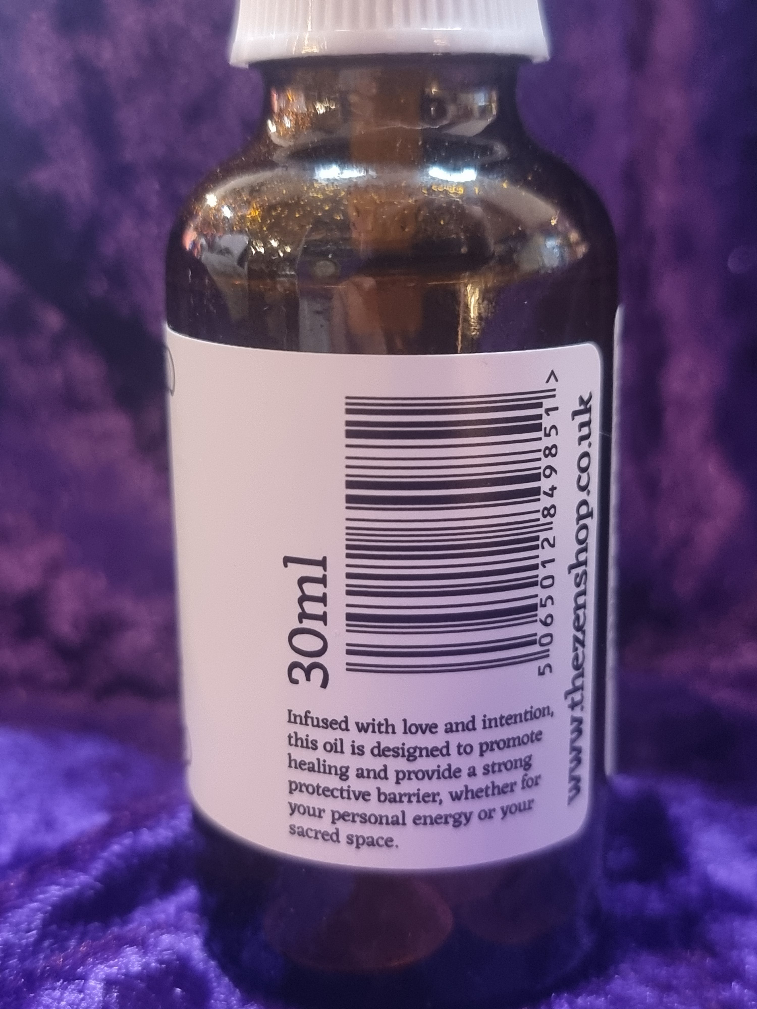 Bottle with a label showing '30ml' and a barcode on a purple textured background