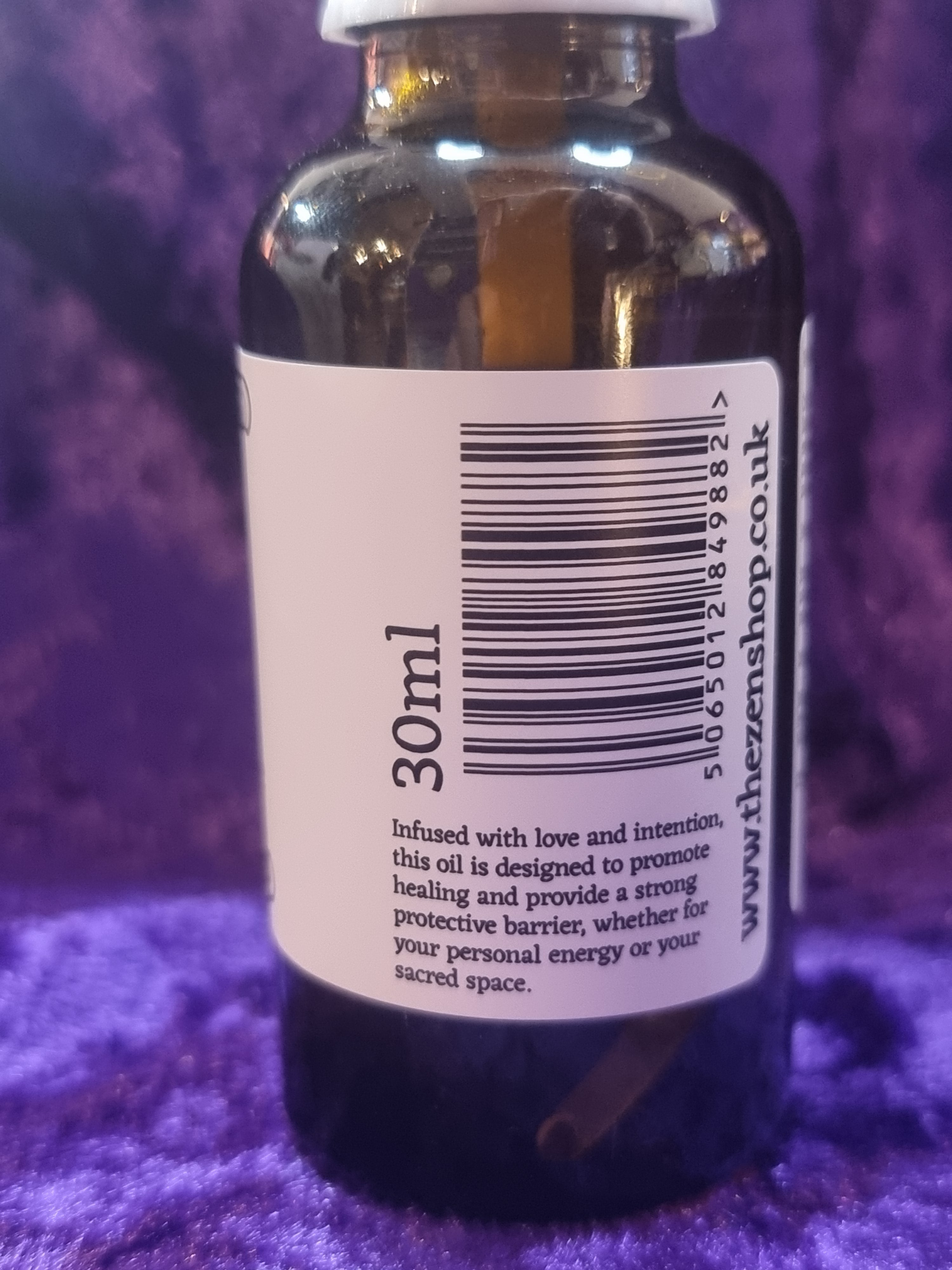 Bottle with a label showing '30ml' and a barcode on a purple textured background