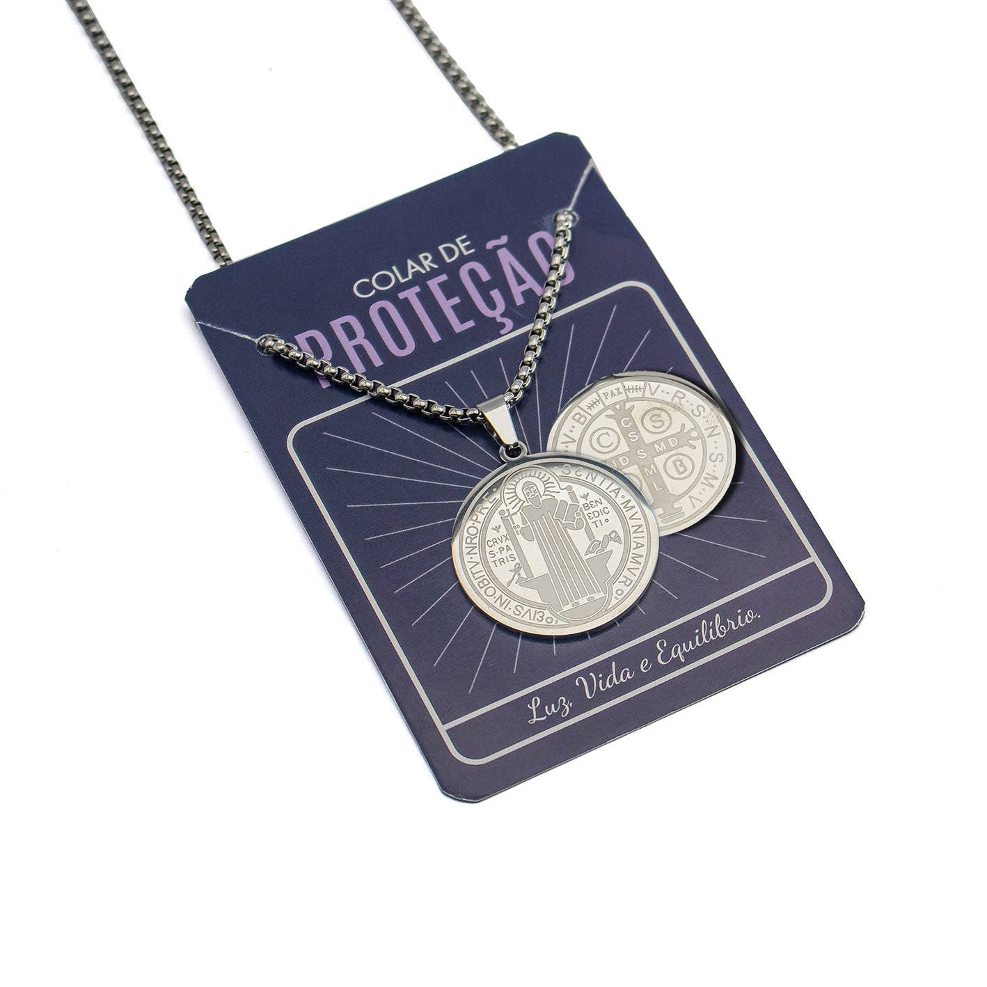 Silver necklace with two circular pendants on a purple card with text.