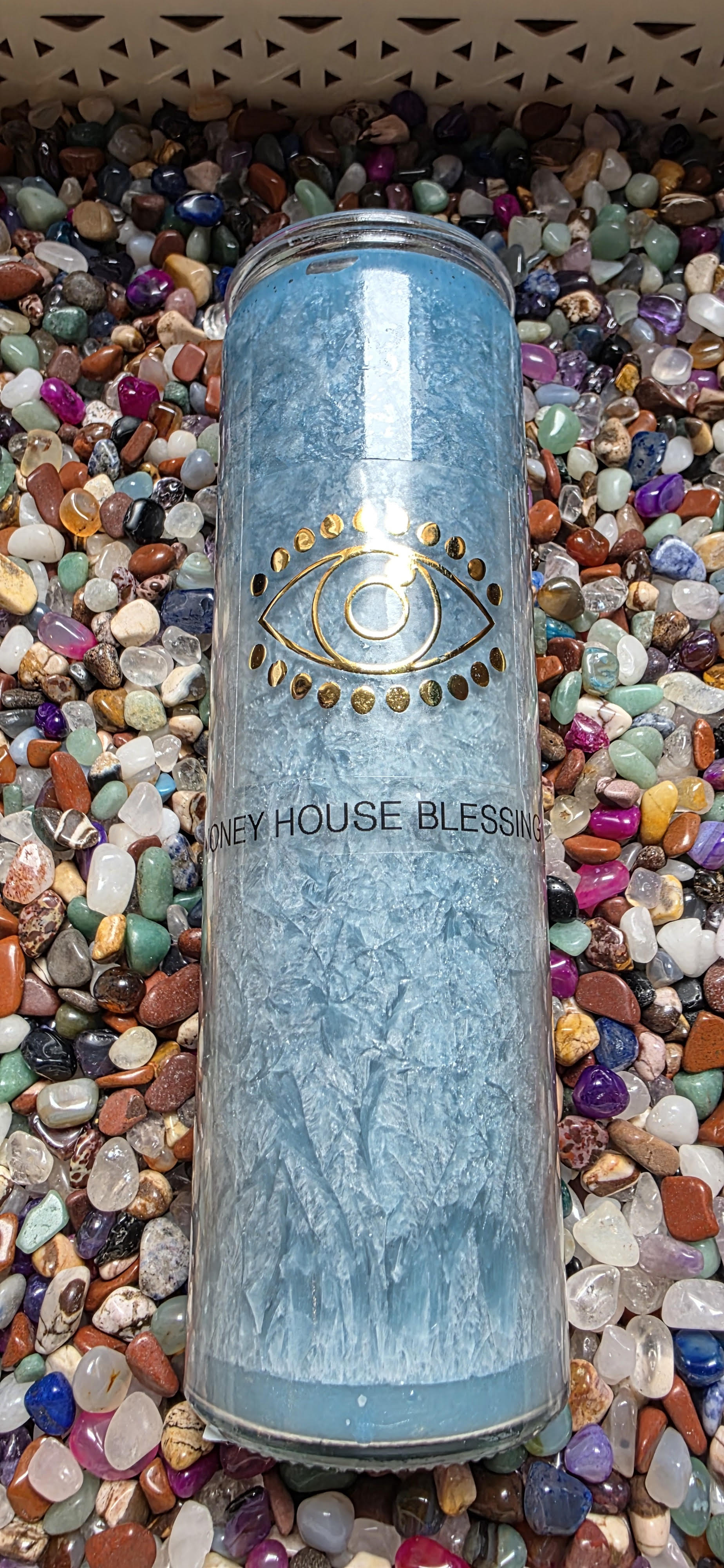 Tall cylindrical container with 'New House Blessing' text on a bed of multicolored stones